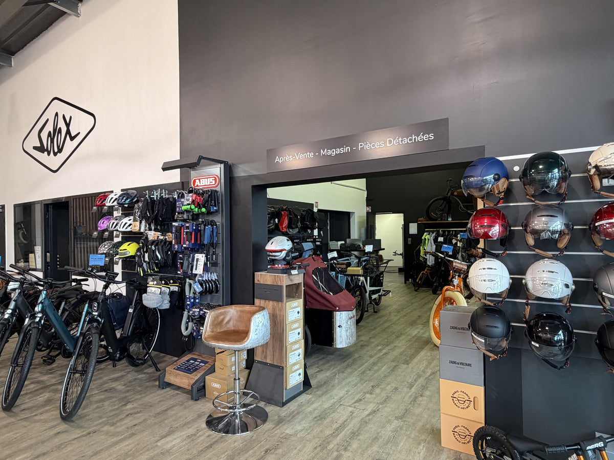Mur de casques et accessoires au magasin E-Bike Caen
